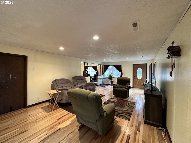 living room featuring a textured ceiling and light hardwood / wood-style floors