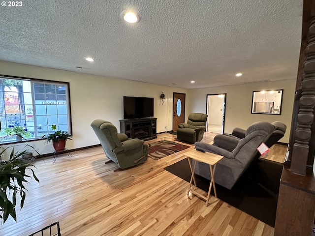 living room featuring a textured ceiling and light wood-type flooring