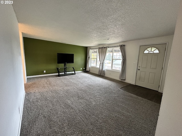 unfurnished living room with carpet flooring and a textured ceiling