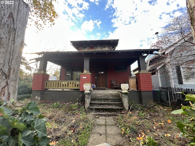 view of front facade featuring fence and a porch