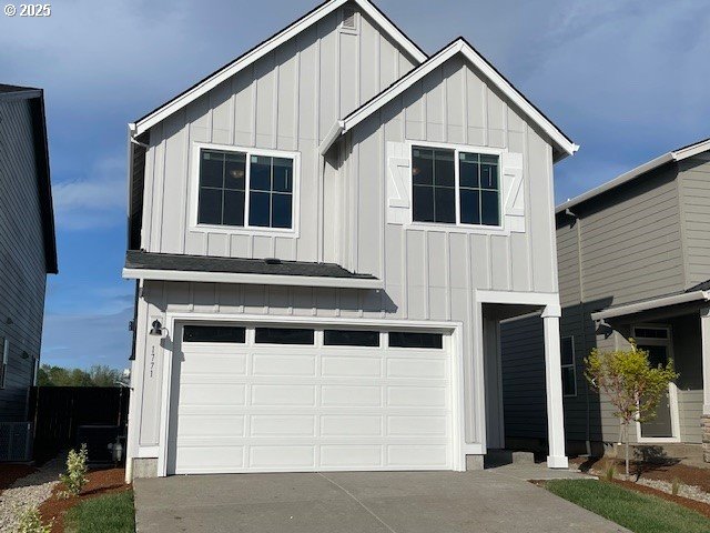 1717 Seven Mile Ln, Albany, OR 97322 - view of front of house with board and batten siding, driveway, and an attached garage