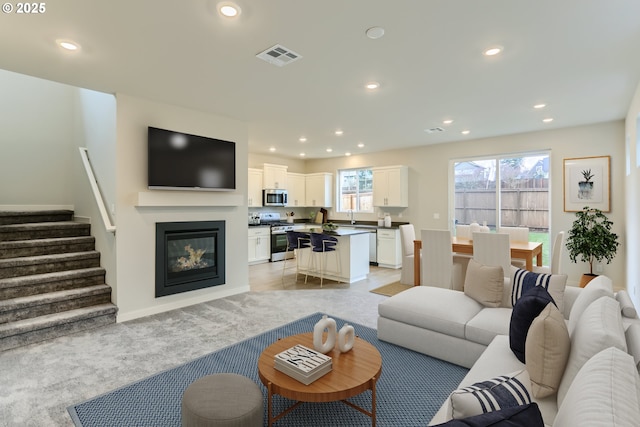 1717 Seven Mile Ln, Albany, OR 97322 - living room with recessed lighting, stairway, light carpet, and a glass covered fireplace