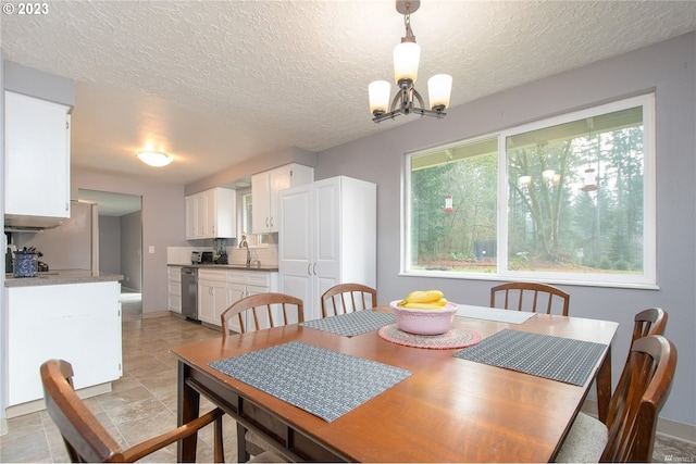 dining room featuring sink, a textured ceiling, and a chandelier