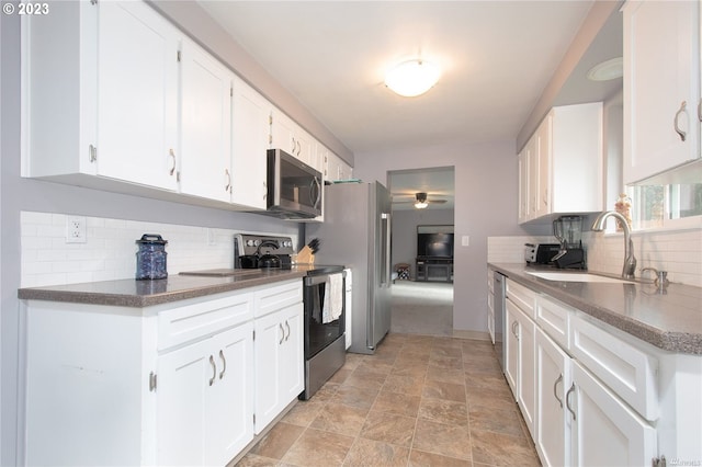 kitchen featuring stainless steel appliances, white cabinetry, sink, and tasteful backsplash