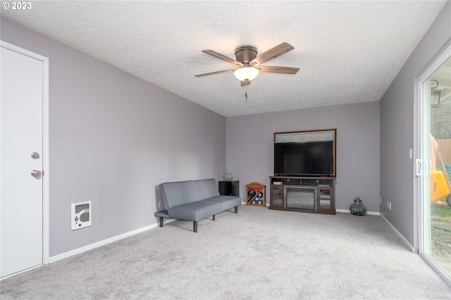 sitting room with a fireplace, a textured ceiling, ceiling fan, and light carpet