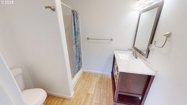 17285 Rustic Ln, Brookings, OR 97415 - bathroom with wood finished floors, toilet, vanity, a shower with curtain, and baseboards