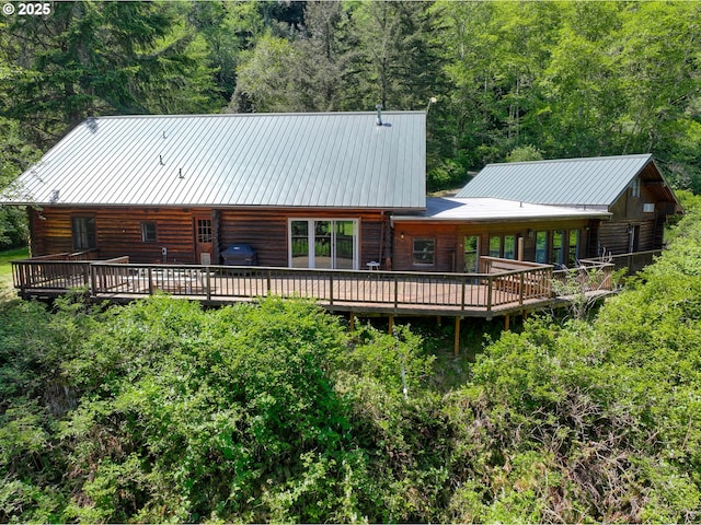 17285 Rustic Ln, Brookings, OR 97415 - back of house featuring a deck, log exterior, a wooded view, metal roof, and a standing seam roof