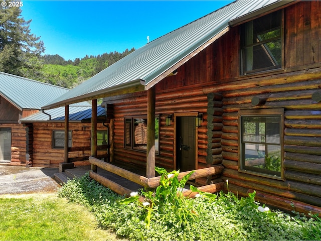 17285 Rustic Ln, Brookings, OR 97415 - rear view of house with log exterior, metal roof, and a standing seam roof