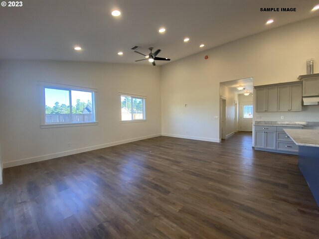 unfurnished living room featuring ceiling fan, dark wood-type flooring, and high vaulted ceiling