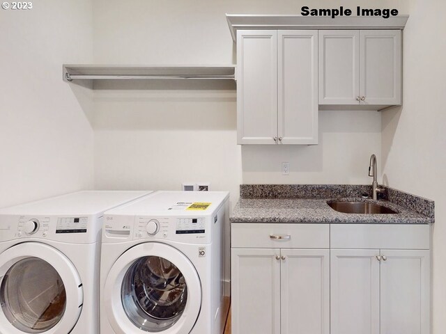 laundry area featuring cabinets, independent washer and dryer, and sink