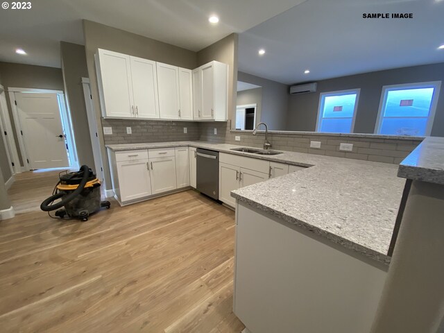 kitchen featuring white cabinets, backsplash, light hardwood / wood-style flooring, and kitchen peninsula