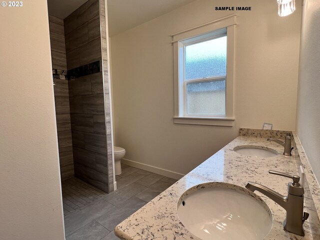 bathroom featuring double sink vanity, toilet, and tile flooring