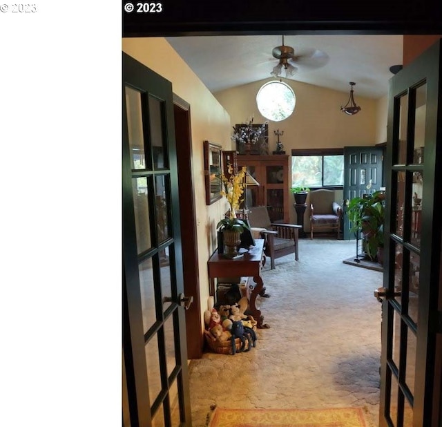 interior space featuring french doors, light colored carpet, vaulted ceiling, and ceiling fan