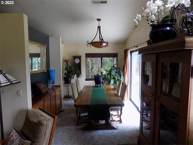 dining space with dark carpet and vaulted ceiling