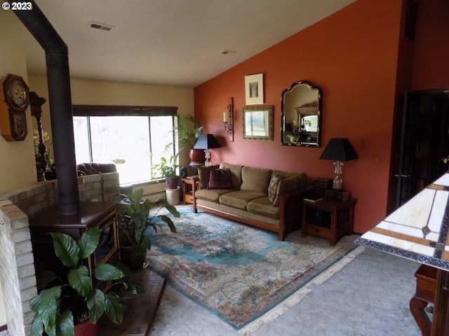 carpeted living room with a wood stove and vaulted ceiling