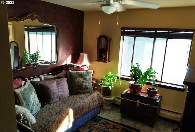 carpeted living room with ceiling fan and a baseboard heating unit