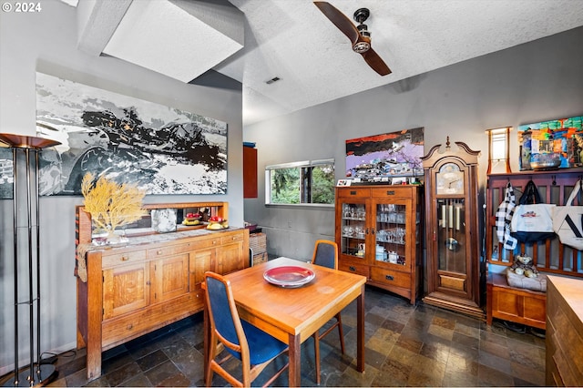 dining area with ceiling fan and a textured ceiling