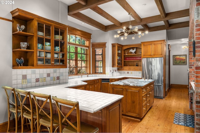 kitchen with backsplash, stainless steel fridge, brown cabinets, and open shelves