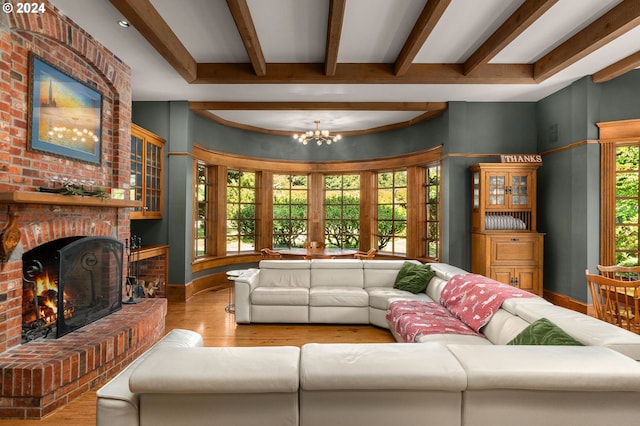 living room with a fireplace, light hardwood / wood-style floors, and a chandelier