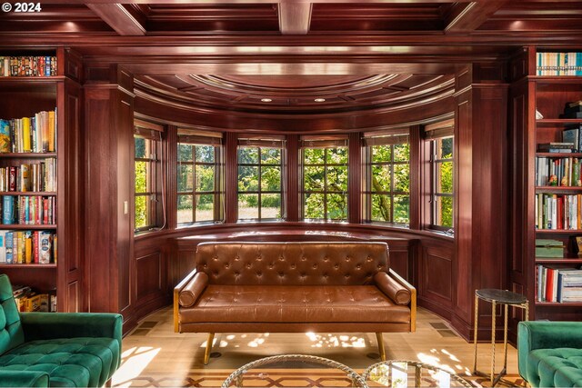 sitting room with wood walls, crown molding, wood ceiling, a premium fireplace, and built in shelves