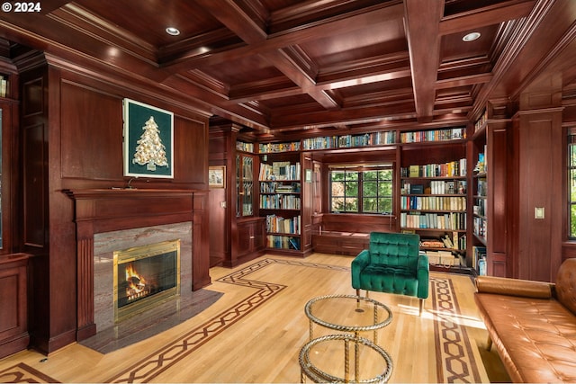 sitting room featuring a premium fireplace, wooden walls, wood ceiling, and coffered ceiling