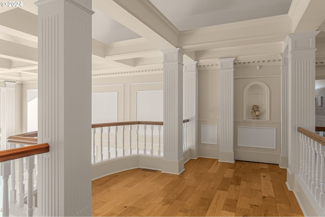 corridor with coffered ceiling, ornate columns, crown molding, light wood-type flooring, and beam ceiling