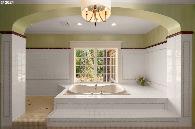 bathroom featuring visible vents, a garden tub, ornamental molding, a notable chandelier, and tile walls