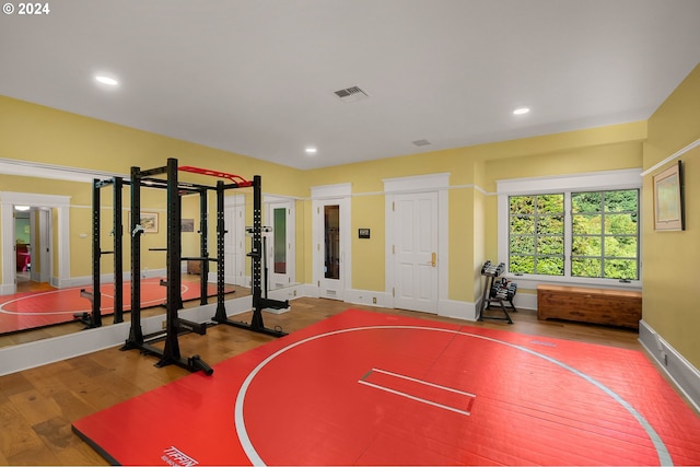 workout area featuring recessed lighting, visible vents, baseboards, and wood finished floors