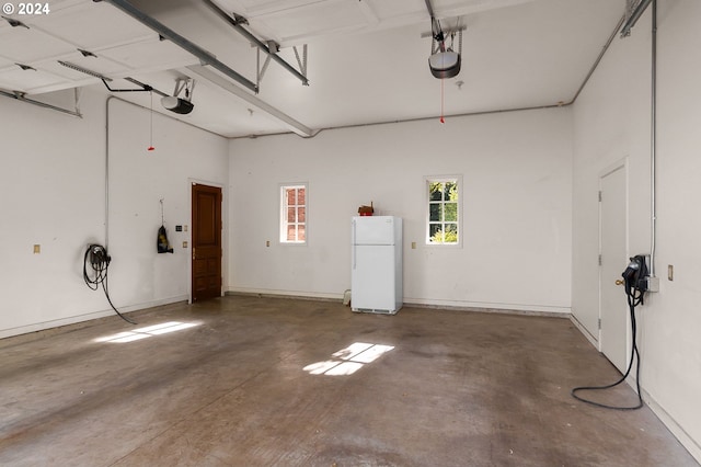 garage with a garage door opener and freestanding refrigerator