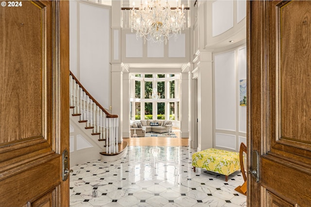 foyer entrance with a notable chandelier and a high ceiling