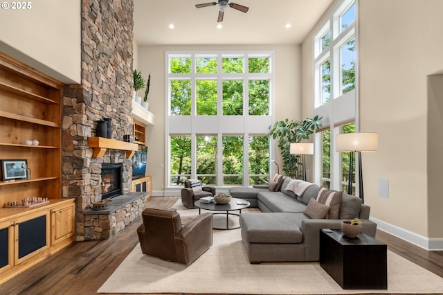 4425 SW 47th Dr, Portland, OR 97221 - living area with a towering ceiling, ceiling fan, baseboards, dark wood-style floors, and a fireplace