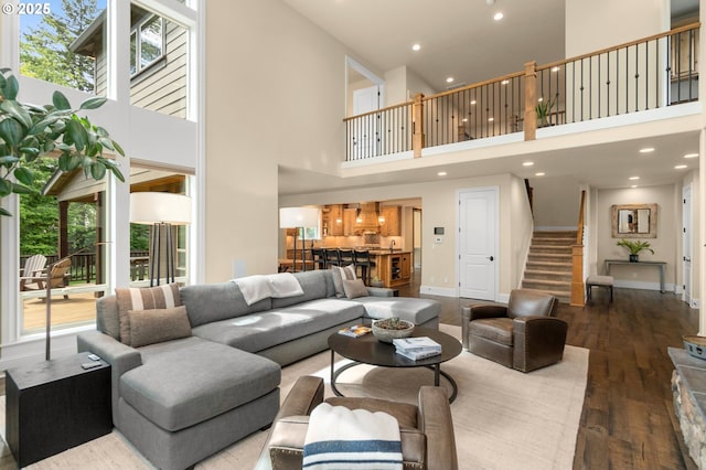 4425 SW 47th Dr, Portland, OR 97221 - living area featuring a towering ceiling, stairs, wood finished floors, baseboards, and recessed lighting