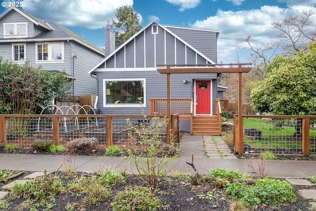 view of front of home featuring board and batten siding and fence