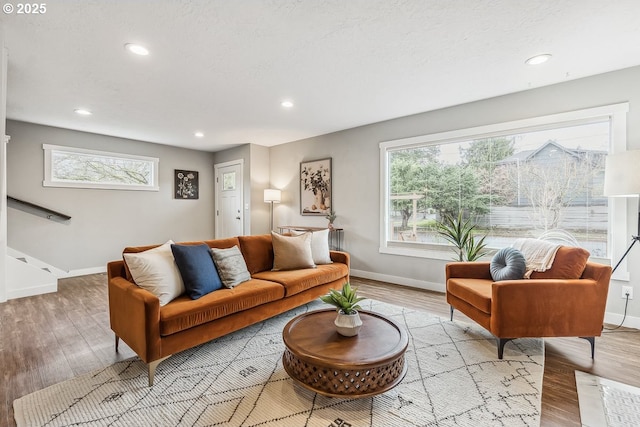 living room with a wealth of natural light, baseboards, and wood finished floors