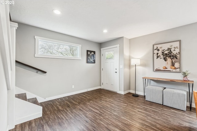 foyer with visible vents, stairs, baseboards, and wood finished floors