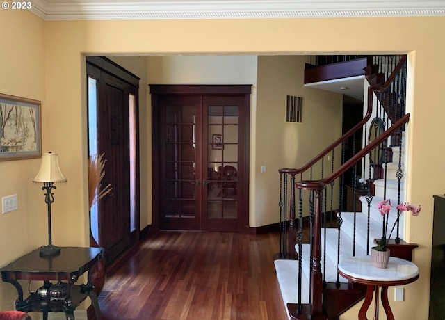 entrance foyer with ornamental molding and dark hardwood / wood-style flooring