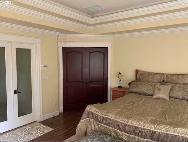 bedroom featuring french doors, ornamental molding, a closet, and dark wood-type flooring