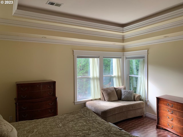 bedroom with crown molding, a tray ceiling, and dark hardwood / wood-style flooring