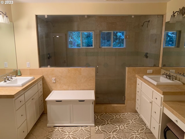 bathroom with tile walls, vanity, and a shower with shower door