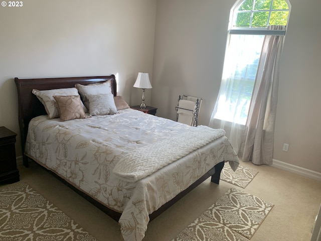 carpeted bedroom featuring multiple windows