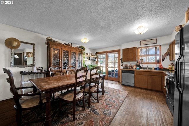 dining space featuring dark hardwood / wood-style flooring, french doors, a textured ceiling, and sink