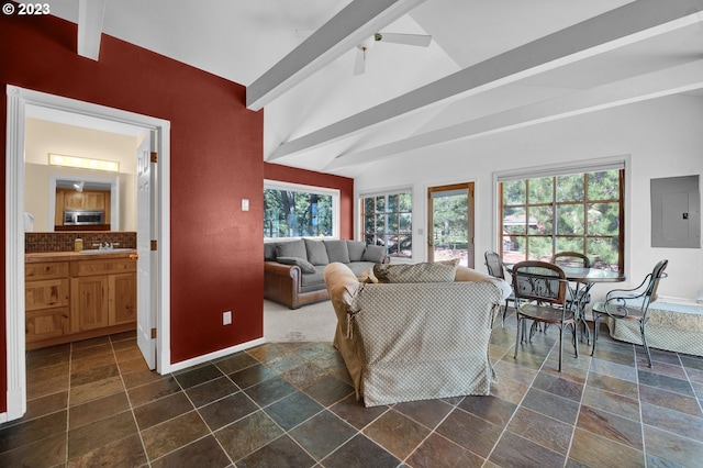 living room with dark tile floors, vaulted ceiling with beams, ceiling fan, and sink