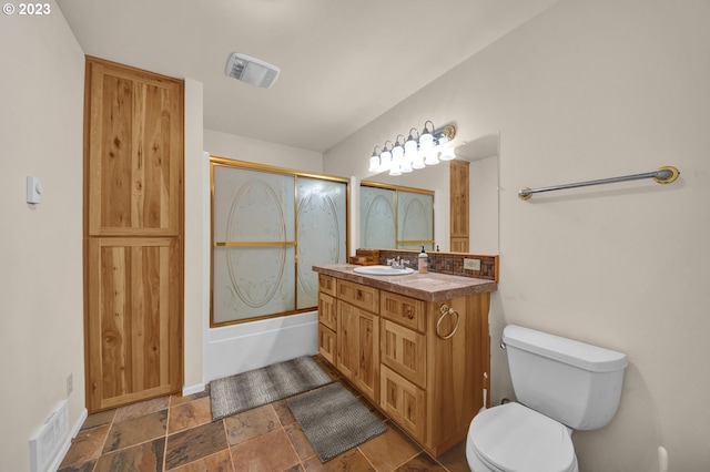 full bathroom featuring tile flooring, enclosed tub / shower combo, toilet, and vanity