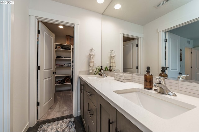 11492 SE Mt Talbert Ave, Happy Valley, OR 97086 - bathroom featuring double vanity, baseboards, a walk in closet, and recessed lighting