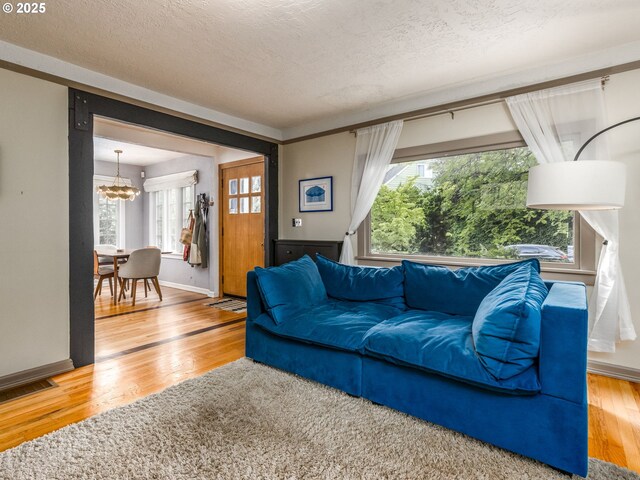 1405 NE 47th Ave, Portland, OR 97213 - living room with a chandelier, wood finished floors, and a textured ceiling