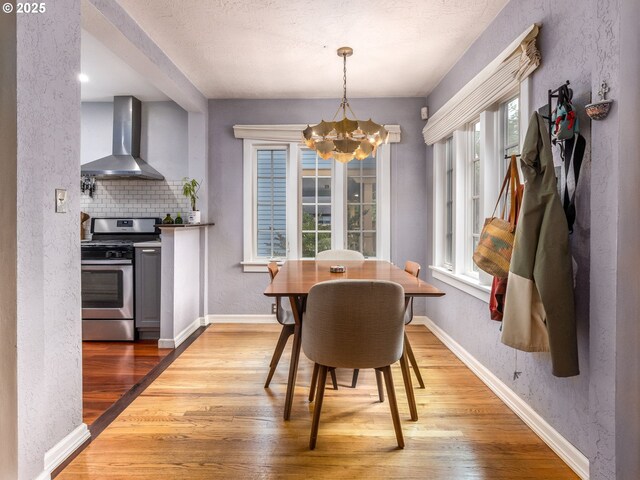 1405 NE 47th Ave, Portland, OR 97213 - dining space featuring a chandelier, wood finished floors, and a textured wall