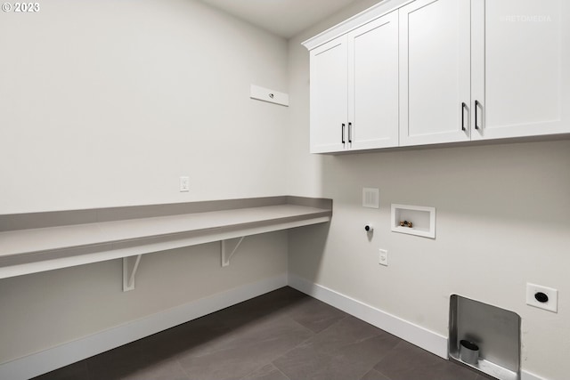 clothes washing area featuring hookup for an electric dryer, cabinets, dark tile floors, washer hookup, and gas dryer hookup