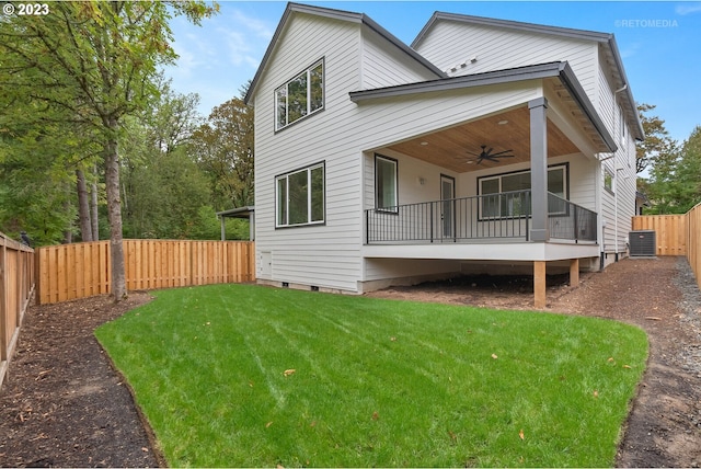 rear view of property with central AC unit, a yard, and ceiling fan