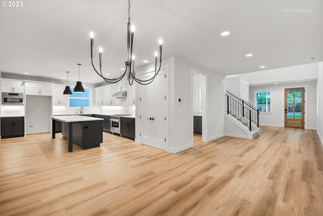 kitchen featuring white cabinets, a chandelier, and light hardwood / wood-style floors