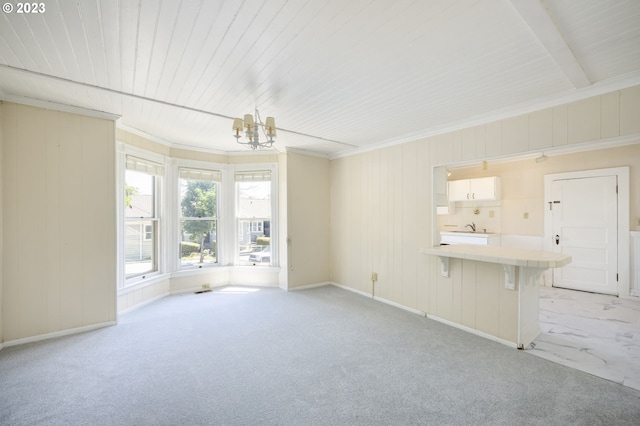 unfurnished living room featuring beam ceiling, a chandelier, light colored carpet, and sink